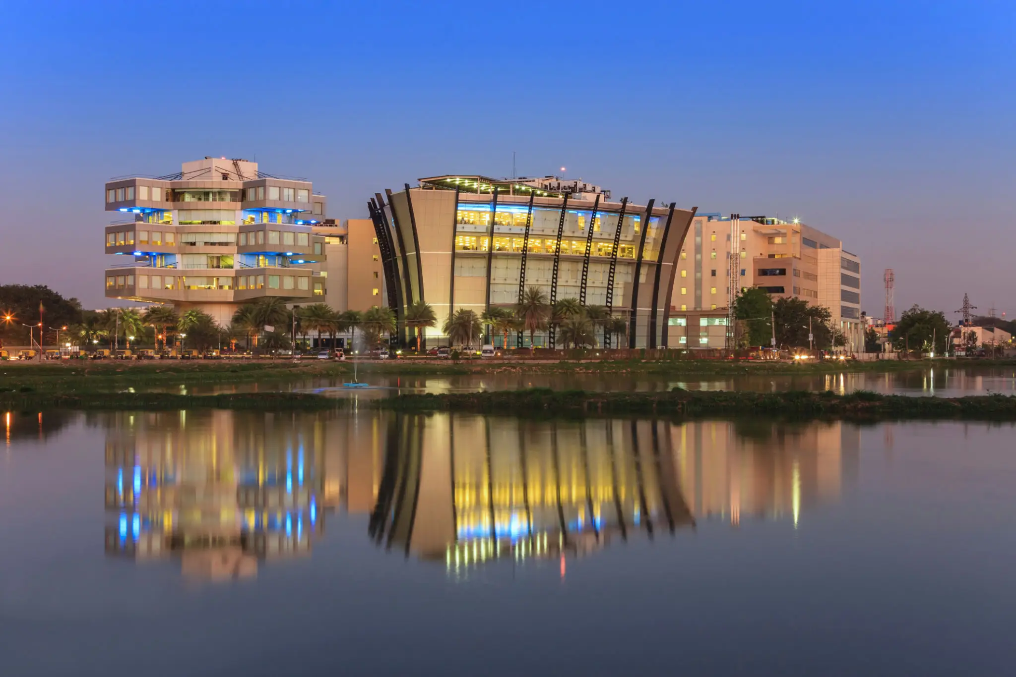 Modern buildings reflecting in calm water.